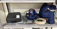 Shelf view showing Waxmaster 900 polisher, blue carry bag, drill case and accessories