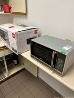 Microwave oven next to original box on countertop