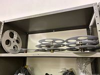 Multiple aluminum film reels stacked on shelf