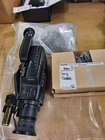Left side view of Sony CCD-V101 camcorder with bubble-wrapped accessories and cardboard box