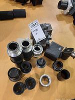 Group shot of all lenses, hoods, adapters and mounting block on table