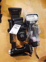 Group shot of three Vivitar flashes, Toshiba QCC10 flash in bag, and Vivitar bracket