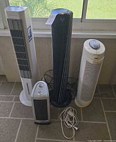 Group shot of four tower appliances and extension cord