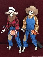 Two dressed skeleton banjo figures standing side by side