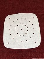 Single square perforated parchment liner displayed flat