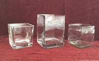 Front view of three clear square glass containers