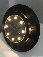 Angled view of round solar disk light showing LEDs illuminated