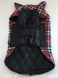 Dog coat shown flat, plaid exterior and quilted lining visible