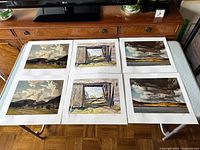 Six A.J. Casson prints laid out on table