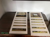 Two stacks of unframed A.J. Casson prints, six per image
