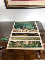 Four unframed prints laid out on table