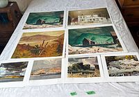 Overview of all eight signed limited edition prints laid out on bed