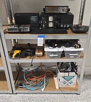 Overview of shelving with electronics, drill, bins of cables