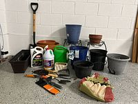 Full lot overview showing shovel, planters, chemicals, hand tools and tote