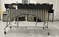 Full front view of vibraphone on rolling stand showing bars, resonators, motor cord, Jenco badge