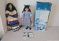 Both dolls, box, papers and stand overview