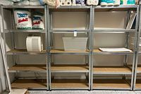 Front view of three matching metal shelving units side by side