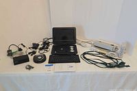 Wide view showing all electronics, keyboard, surge protectors, cords, adapters and DVD disc