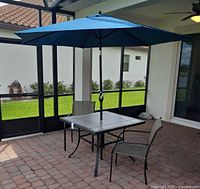Table with umbrella and chairs on patio