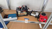 Shelf view showing all four items: inverter box, battery charger, inflator, red variac