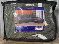 Front view of packaged Subrtex L-shaped sofa slipcover set in zippered bag