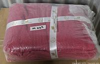 Sealed package of cranberry cotton towel set with EcoFriendly ribbon