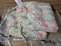 Pair of paisley outdoor cushions stacked on packaging