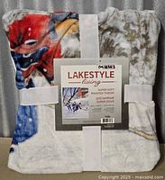Front view of packaged throw showing brand label and partial design
