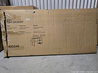 Sealed cardboard carton showing Sauder branding and model information