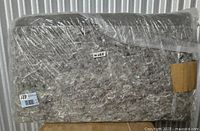 Rug pad rolled, wrapped in clear plastic, size label and lot sticker visible