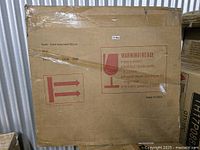 Sealed cardboard box labeled “Wall mounted Mirror” with handling icons and SKU area blank