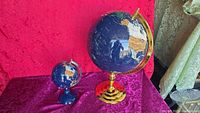 Both globes side by side showing relative sizes and stands