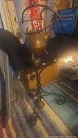 Full view of kettle suspended on wrought iron stand