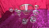 Full view showing serving bowl and seven matching silver-rimmed glasses