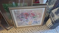 Floral still life print in frame leaning against wall