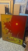 Front view of signed Arturo Alcala painting with red sky, golden sun, animals and foliage