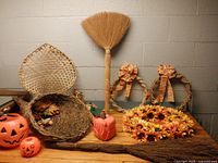 Group shot showing cornucopia, brooms, pumpkin buckets, wicker chair basket, wreaths, pumpkin cover
