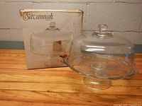 Box with Savannah branding beside glass cake stand and dome