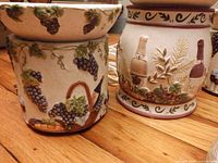 two ceramic electric warmers with grape/wine bottle motifs