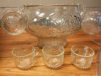 Punch bowl with three cups attached, three cups on table