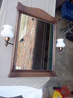 Front view of cabinet showing mirror door and both hobnail sconces