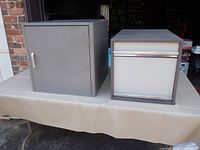 Gray single-door cabinet and brown two-drawer file cabinet front view
