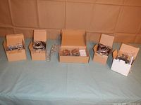 Five cardboard boxes containing coiled wire light strands with battery packs