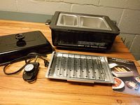 All components: roaster oven with two half pans, lid removed, control probe, rack, manual