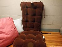 Front view showing merlot rocker cushions, pink pillow, striped pillow