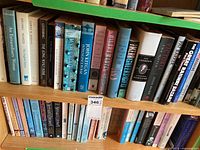 Top shelf showing mix of hardcovers and paperbacks including Intelligence in War and Guns Germs and Steel