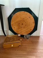 Crokinole board, labyrinth game, bag of discs displayed together
