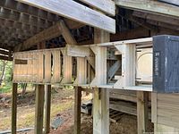 Full view of Featherlite fiberglass step ladder stored horizontally under deck, showing all 13 steps and black molded top