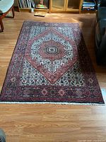 Full view of Persian Gholtough rug on floor showing pattern and overall condition