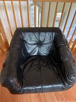 Front view of black leather chair in wooden frame